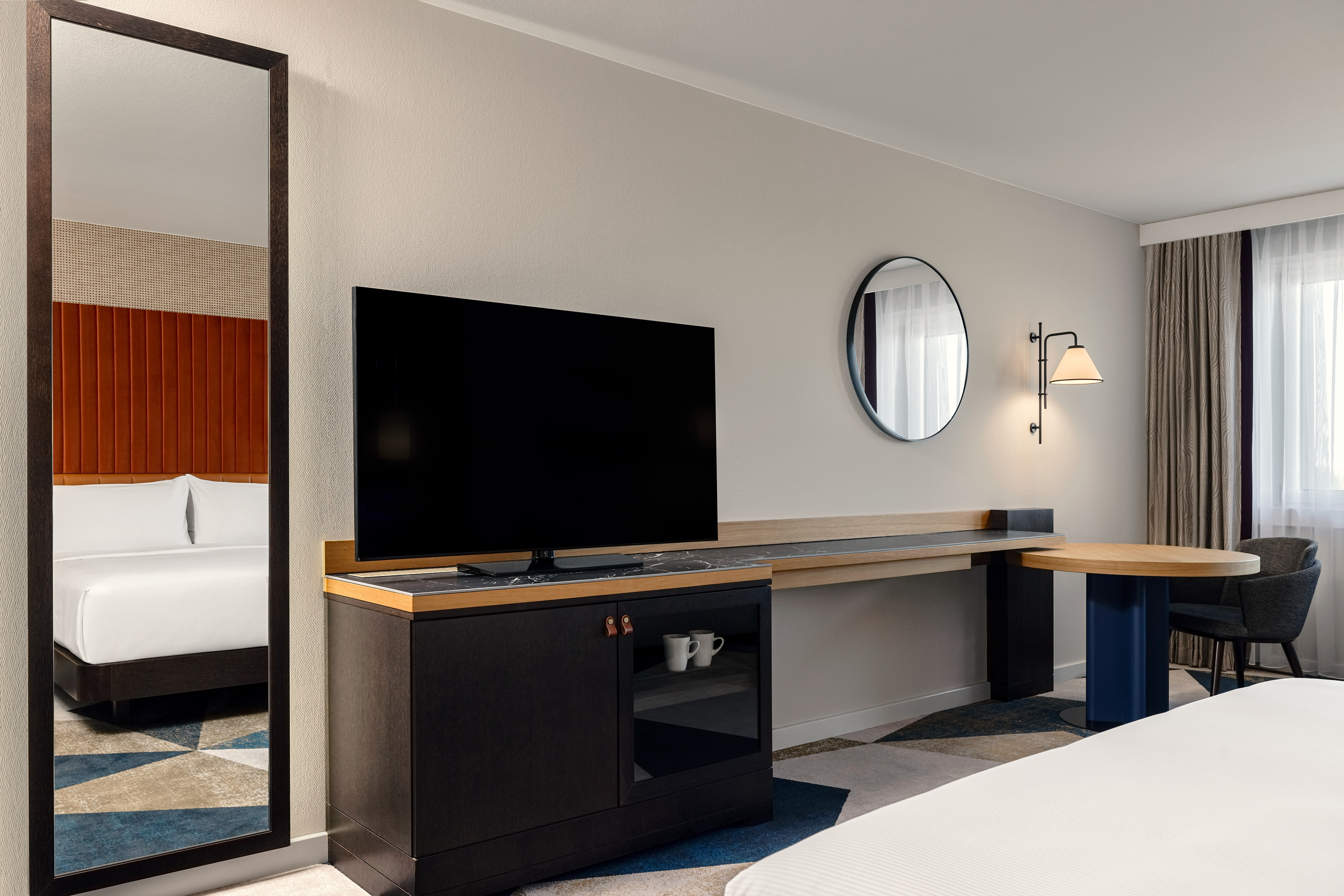 HDTV, Mirror and Desk Area in a Guest Room