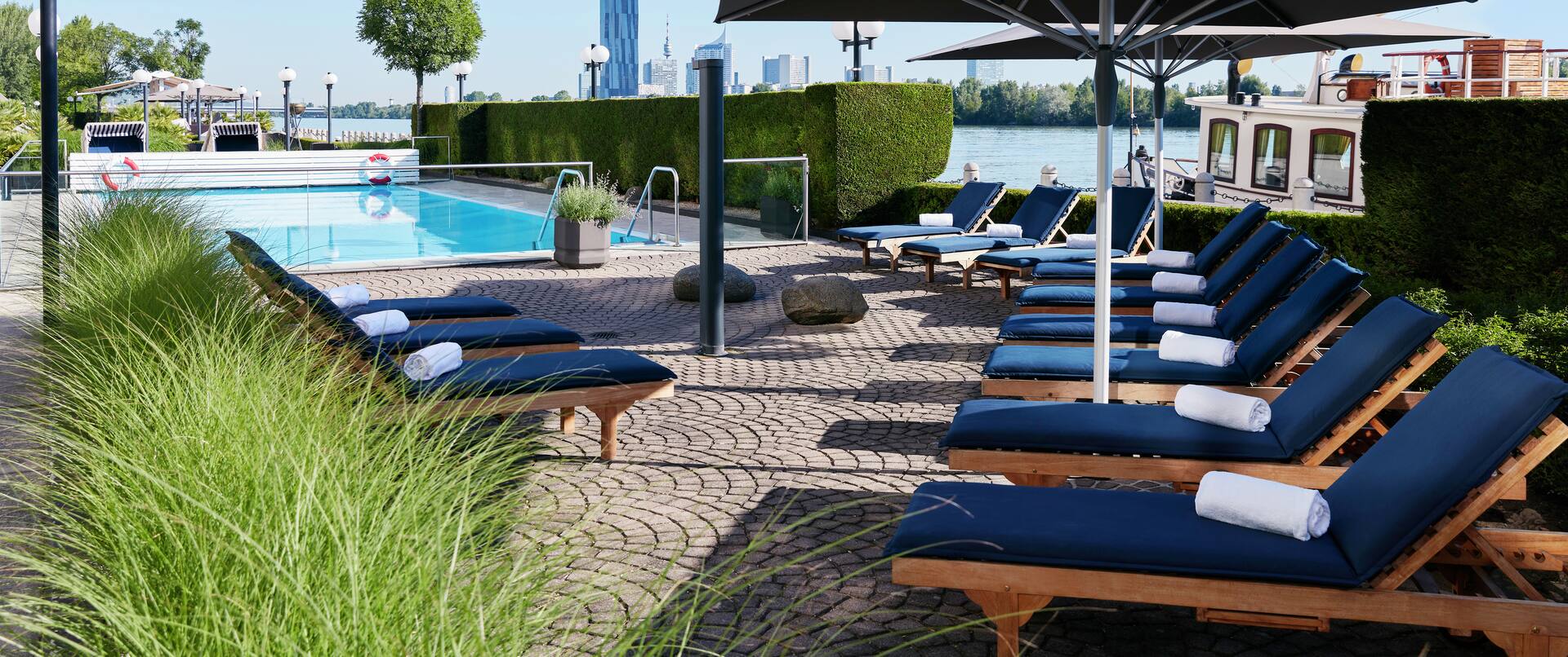 Pool im Freien mit Liegestühlen und großen Sonnenschirmen