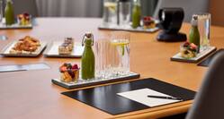 Boardroom Table Detail with Notepads Pens Drinks and Fresh Fruits