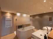 Suite bathroom with tub and two sinks