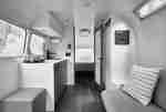 Dapur dan sofa di Airstream dengan pemandangan dari pintu ke kamar tidur