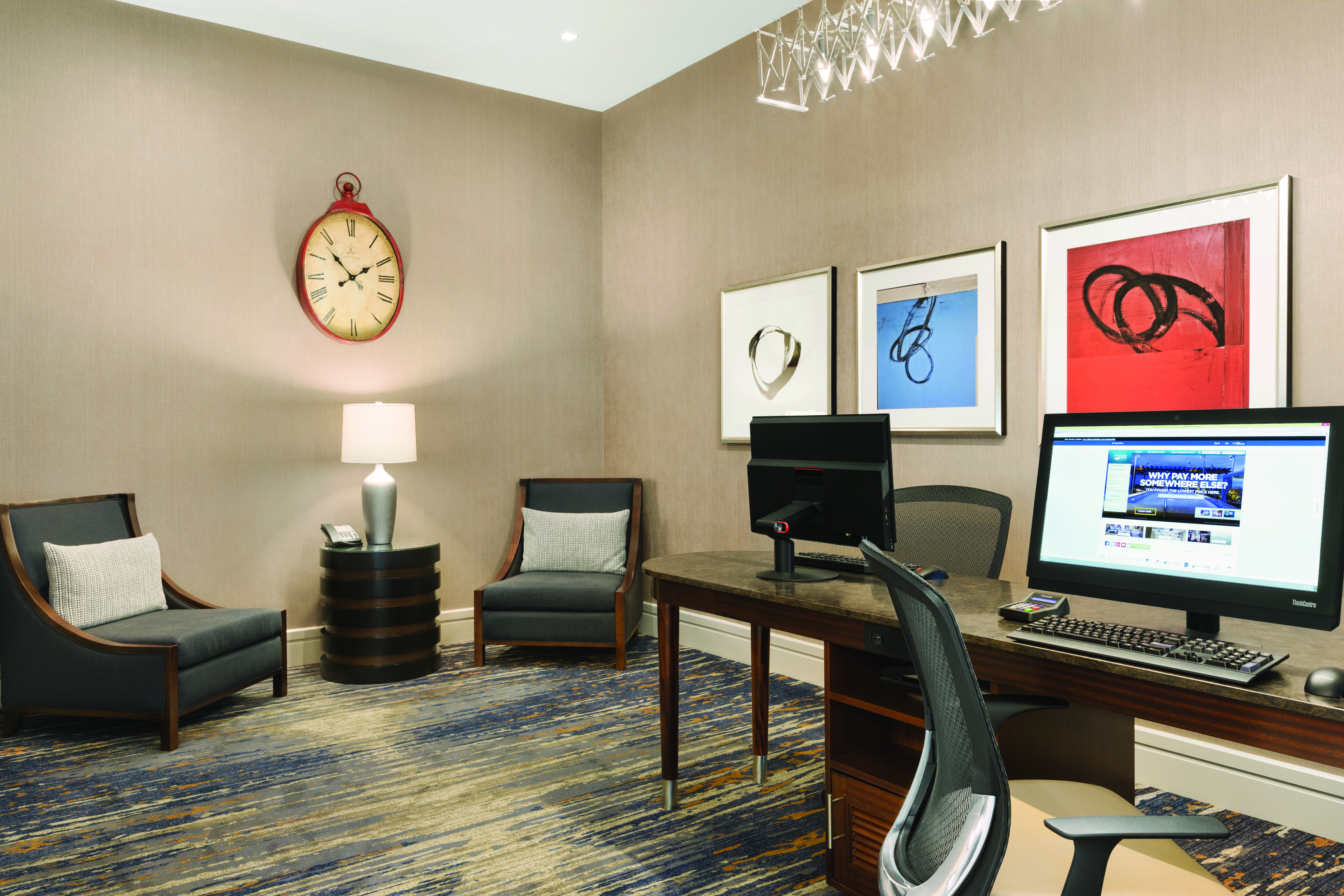 Business Center With Two Computer Workstations, Rolling Chairs, Wall Art, Table With Lamp and Two Arm ChairsComputers and Office Chairs in the Business Center