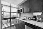 Fridge by Large Window, Microwave Over Stovetop, Sink, Coffee Maker, Toaster, and Dishwasher in Kitchen of King Suite