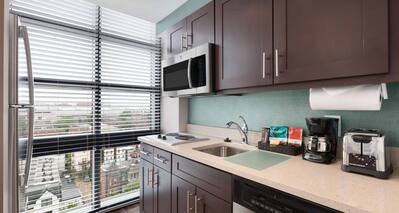 Fridge by Large Window, Microwave Over Stovetop, Sink, Coffee Maker, Toaster, and Dishwasher in Kitchen of King Suite