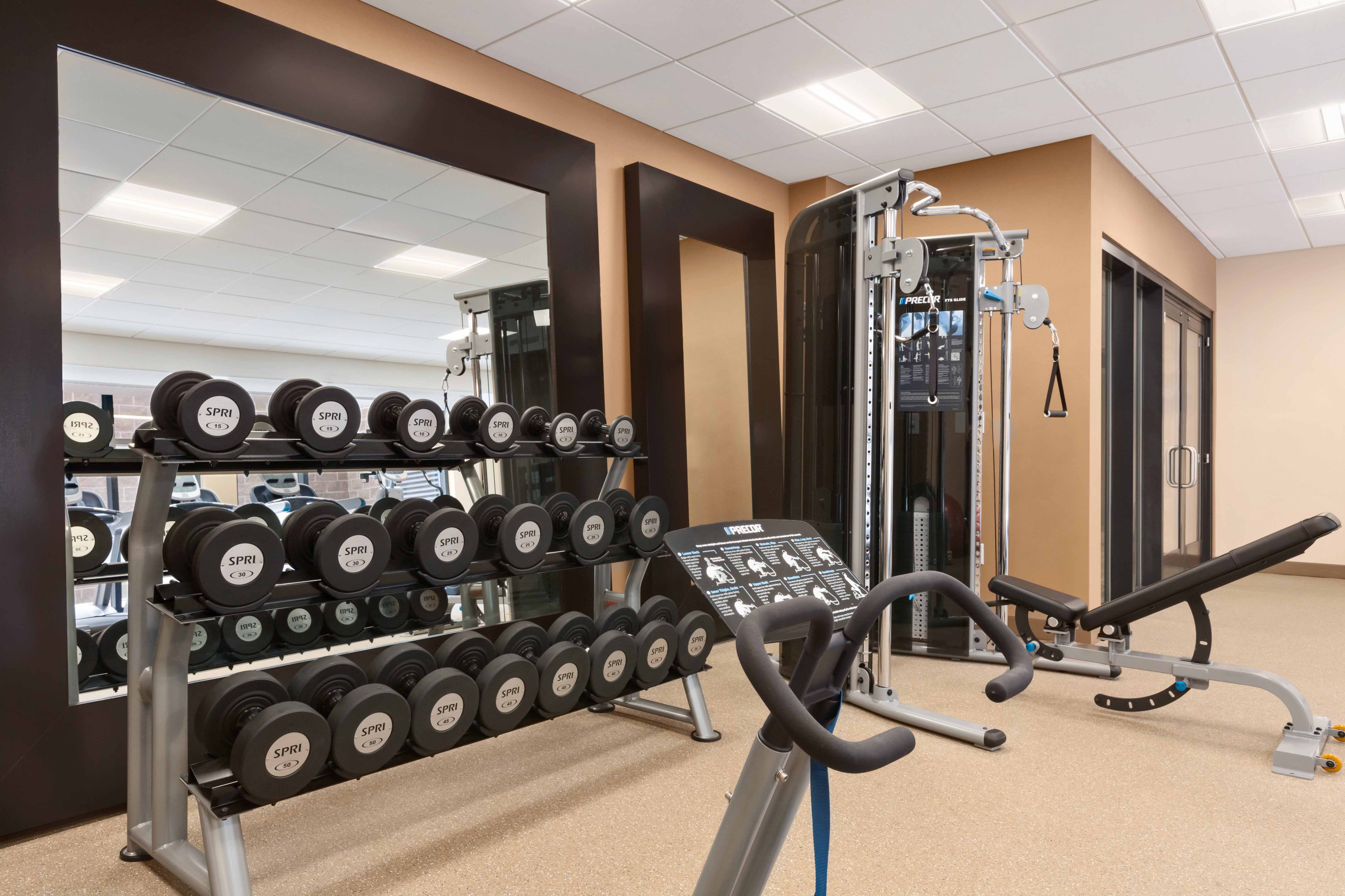 Fitness Center With Free Weights by Large Mirror, and Cardio Equipment
