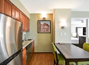 Suite Kitchen, Dining Table With Seating for Two, and Open Doorway to Bedroom 
