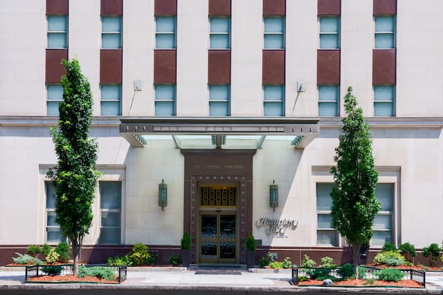 Hotel exterior with signage and trees