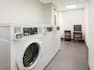 Laundry room with machines and chair