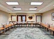 Meeting Room in Classroom Style With Decorated Long Tables and Chairs Facing Podium