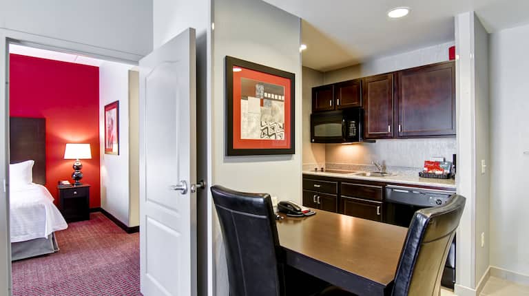 View of Kitchen, Wall Art, Dining Table for Two, and Open Doorway to Bedroom