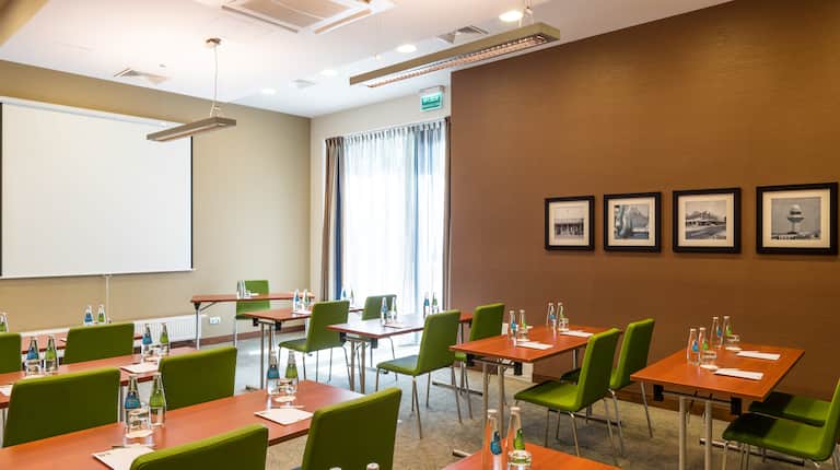 Hotel Hampton by Hilton Warsaw Airport, Polska – Zielone krzesła i biurka w sali konferencyjnej
