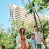 Family Walking on Hotel Grounds with Palm Trees