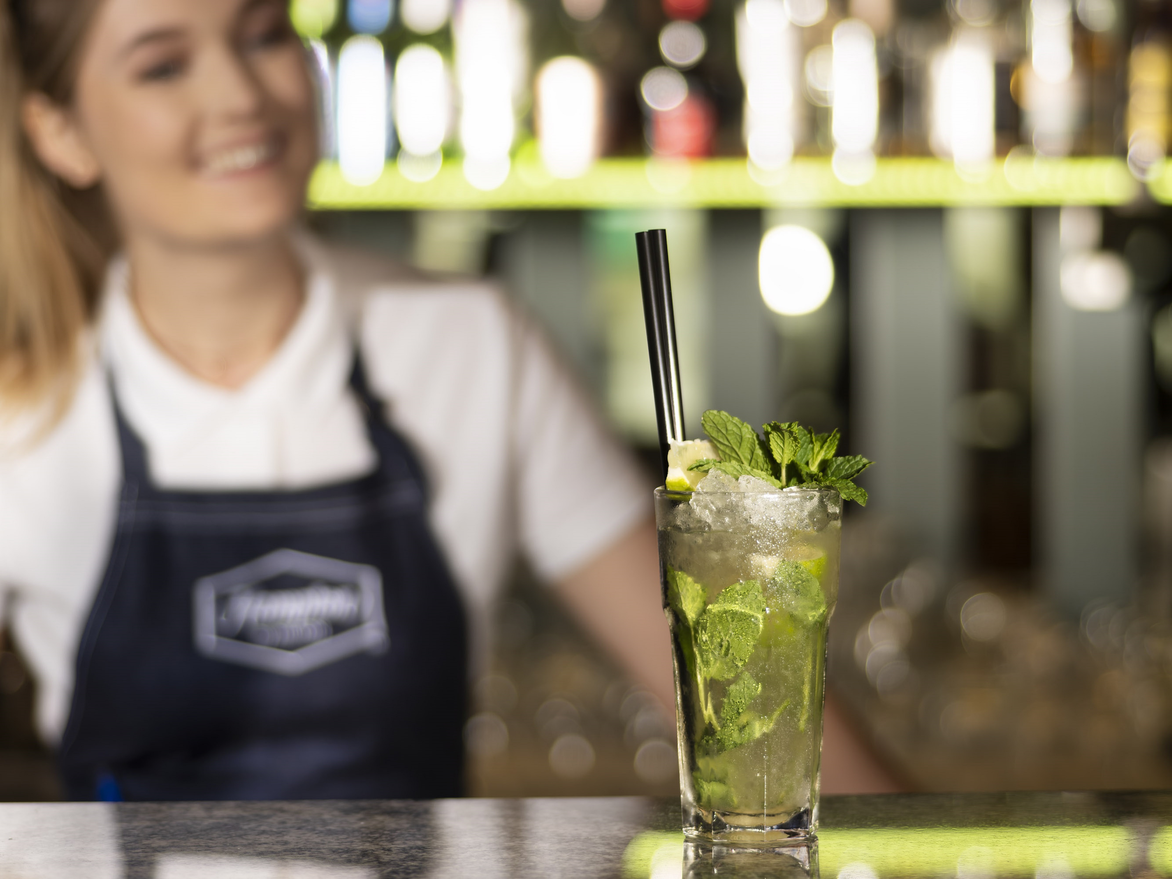 a Woman at a Bar with a Mojito Glass on a Counter at a Bar