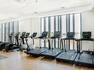 Treadmills and Recumbent Bikes in a Fitness Room with Large Windows