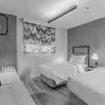 İki yatak, çalışma masası ve sandalye bulunan misafir odası.