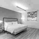 Bir yatak, yan masalar, bir zemin lambası ve bir pencere bulunan misafir odası.