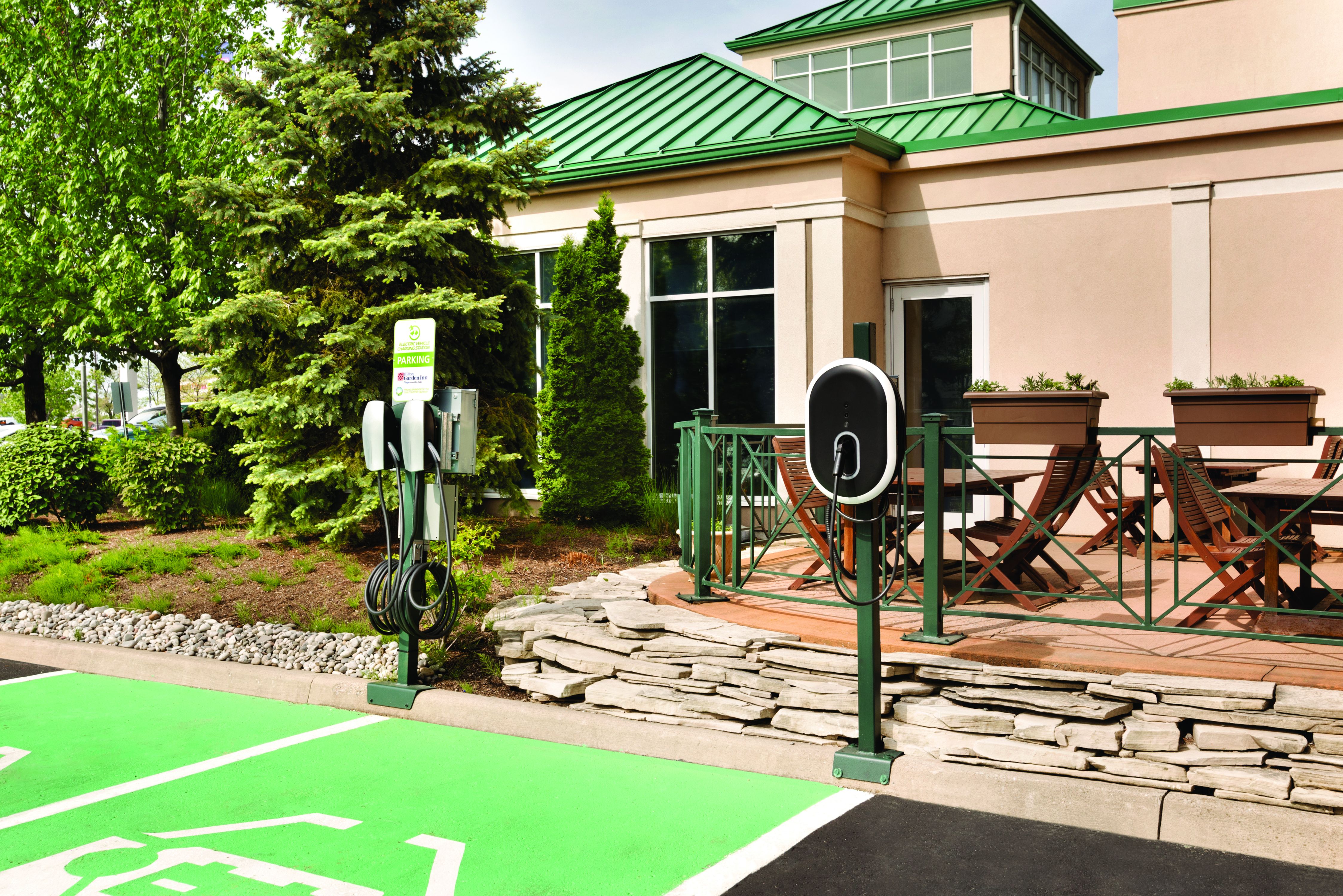 Electric Car Charging Station on Parking Lot by Hotel Exterior