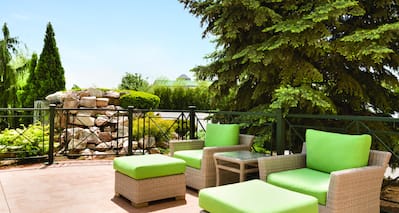 Chairs and Ottomans With Green Cushions on Outdoor Patio