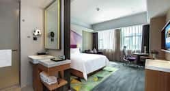   King Superior Deluxe Room  with Bed, workdesk, TV, outside view and view of shower/Bathroom area