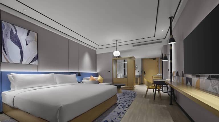 King bed room with sofa and wall mounted TV