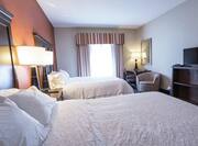 Comfortable queen beds in bright guest room