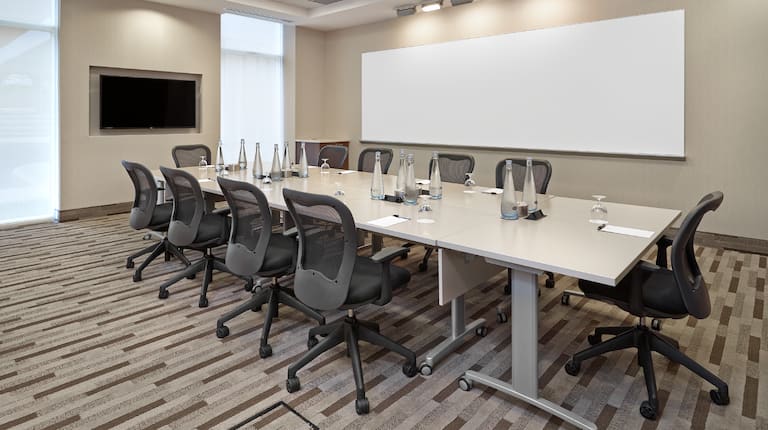 Conference Center With Windows, TV, Whiteboard, and Seating for 10 Around Boardroom Table