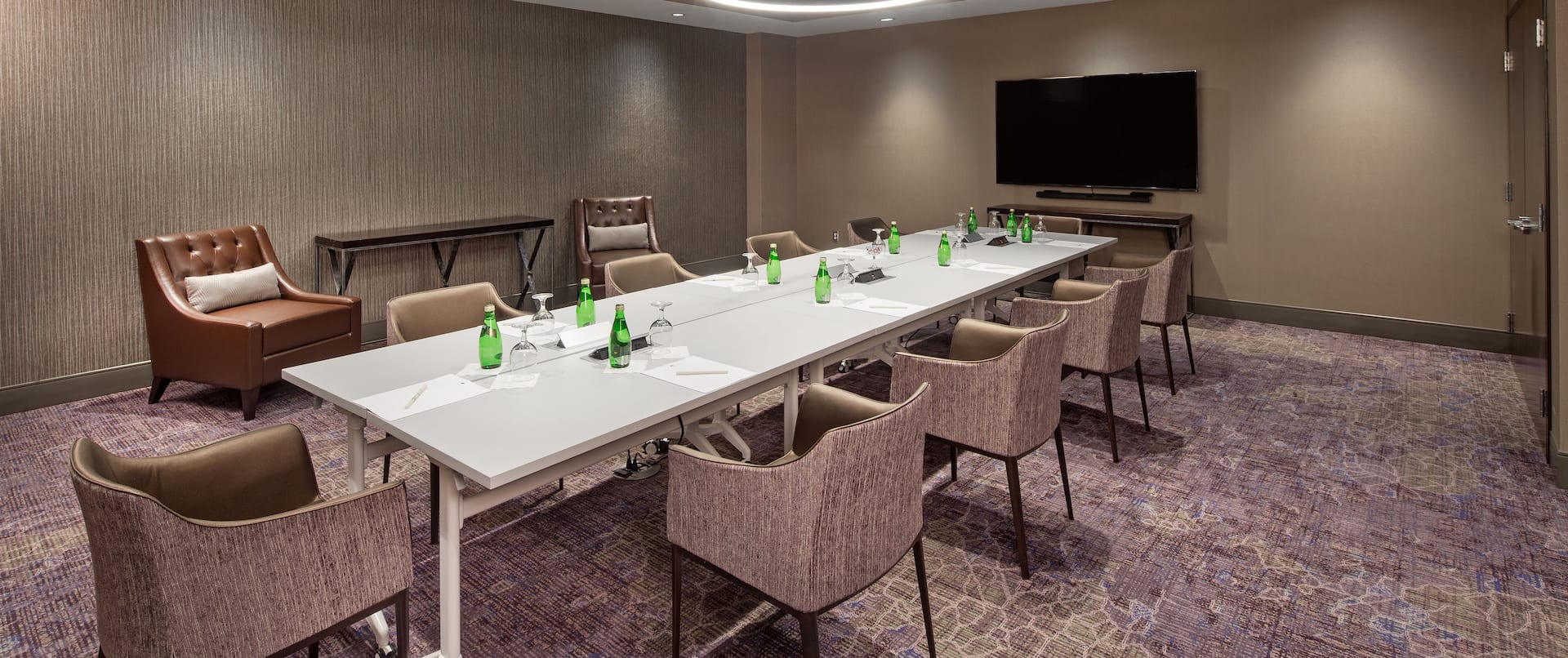 Meeting Room with Long Table, Armchairs and Wall Mounted HDTV
