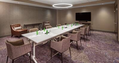 Meeting Room with Long Table, Armchairs and Wall Mounted HDTV
