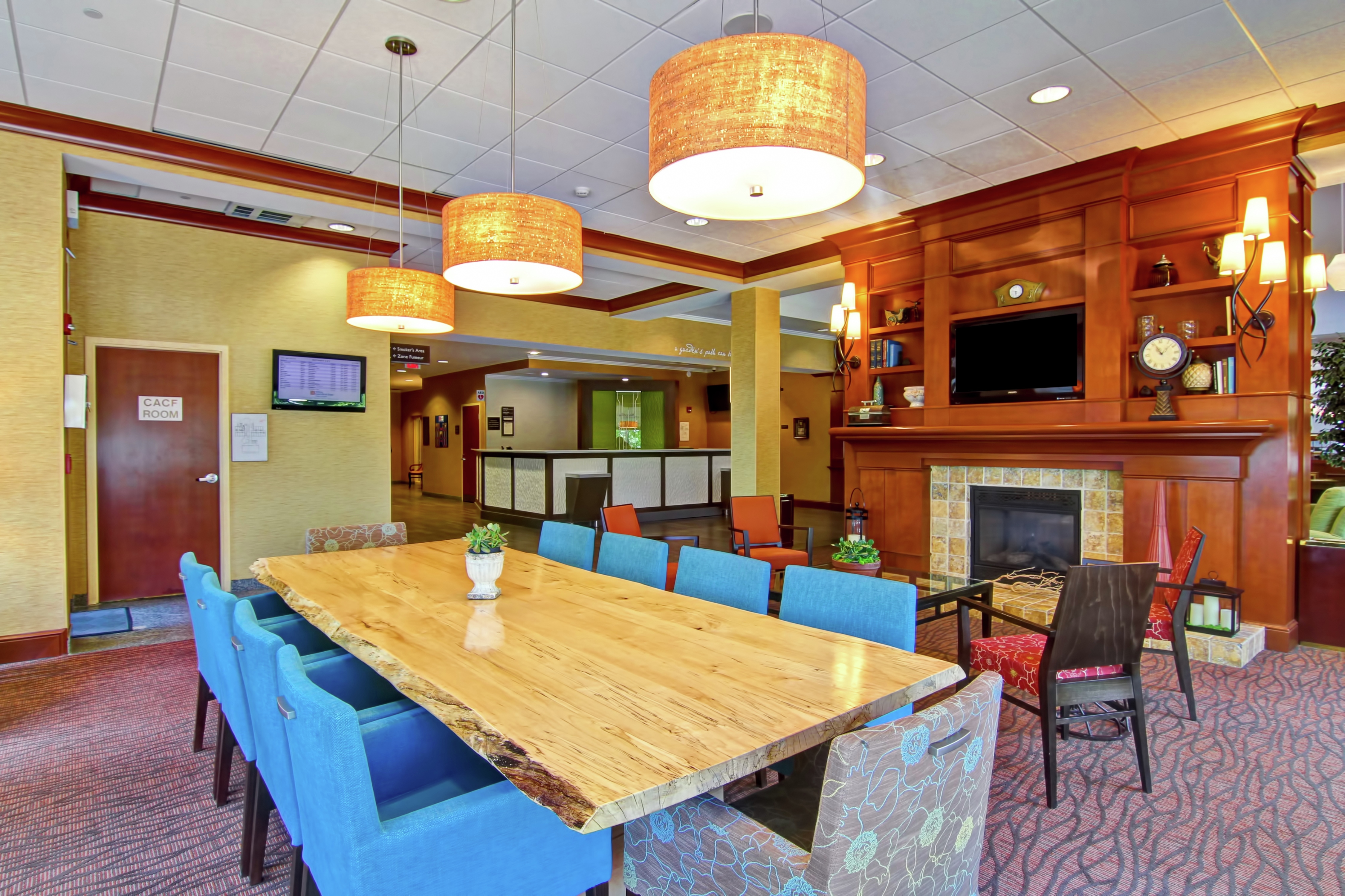 Seating for 10 at Large Table, Additional Seating in Lobby Area With Fireplace and View of Front Desk in Background