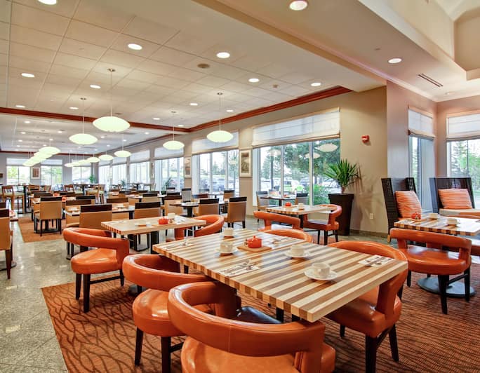 Tables, Chairs, and Large Windows in The Garden Grille Dining Area