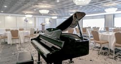 a black grand piano in a banquet room