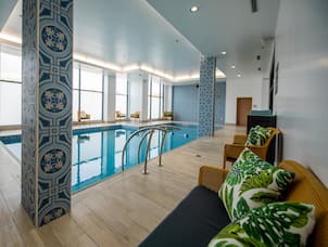 Indoor Pool with Large Windows and Seating Area
