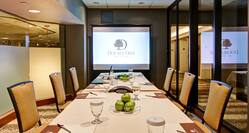 Small Conference Meeting Room with Seats, Projector Screen and Table with Notepads