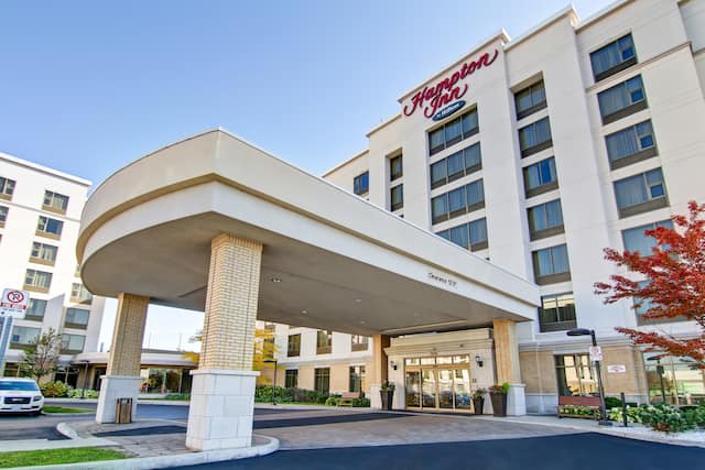 Front hotel exterior with circle drive under covered entrance