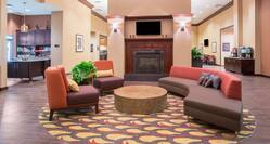 Soft Seating and Round Table in front of TV Above Fireplace in Lobby With Views of Snack Shop and Beverage Service Area
