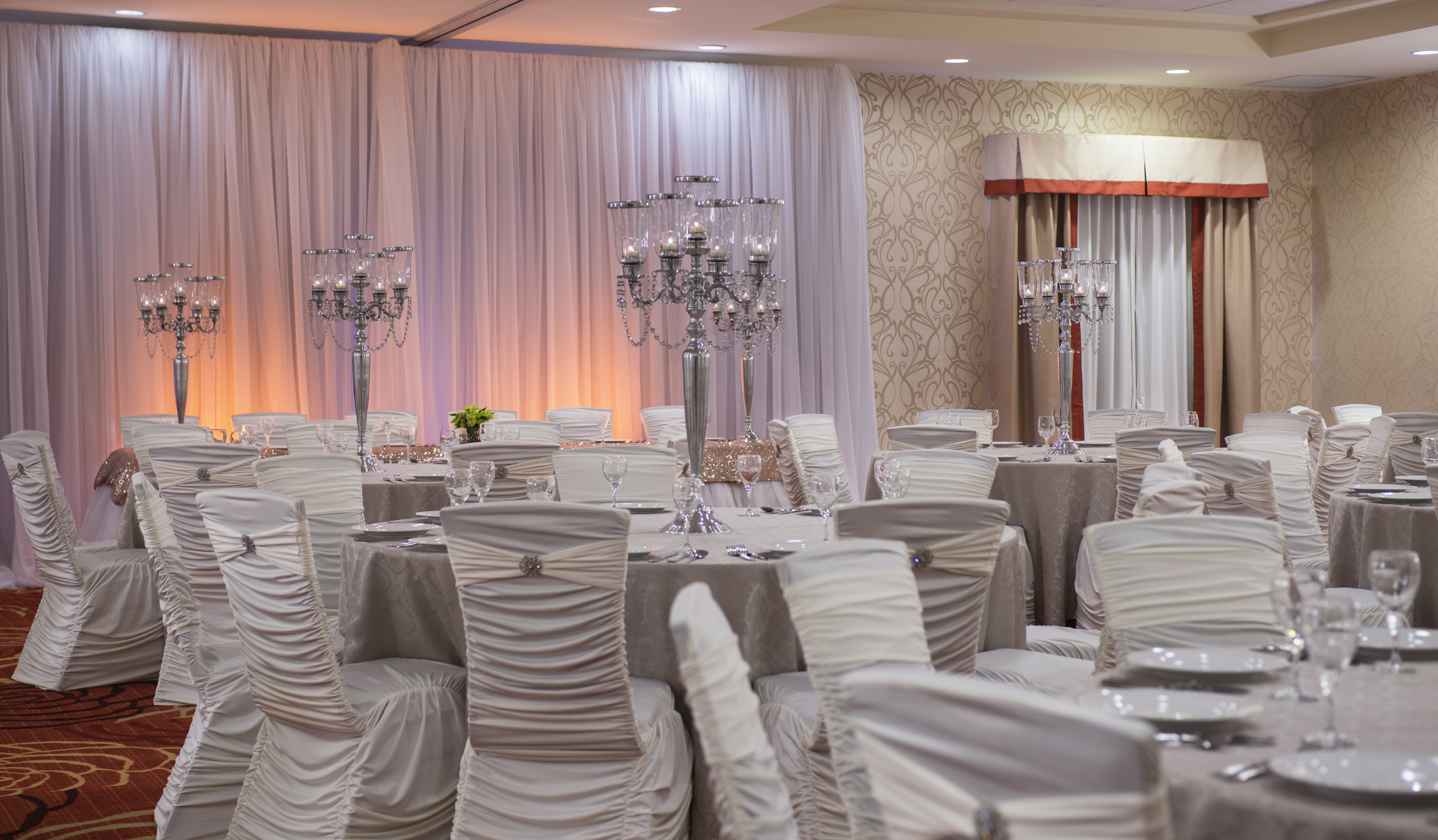Ballroom With White Tablecloths on Round Tables Set Up for Wedding Reception 