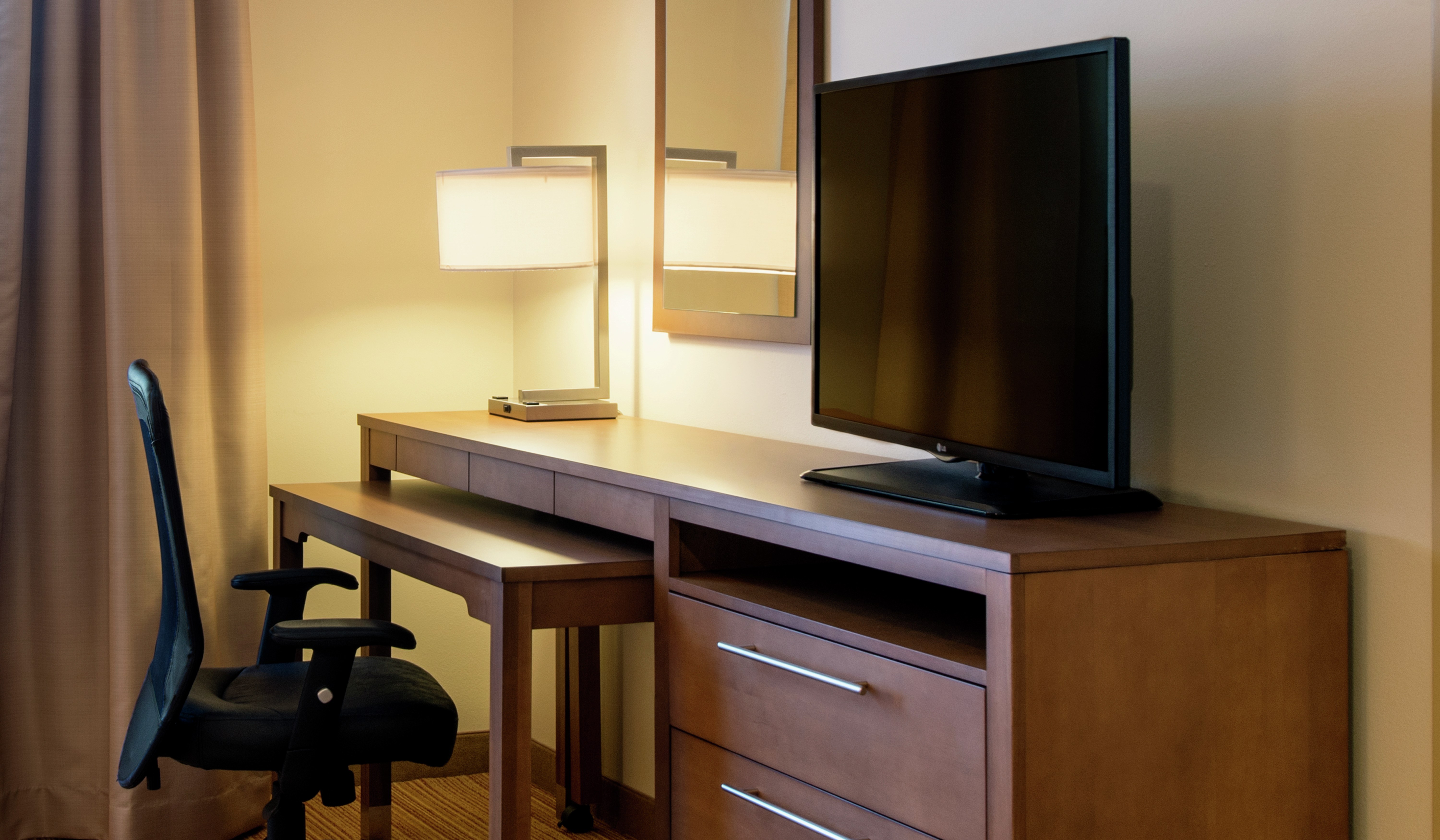 Work Desk, Dresser, and Flat Screen TV in Guest Room