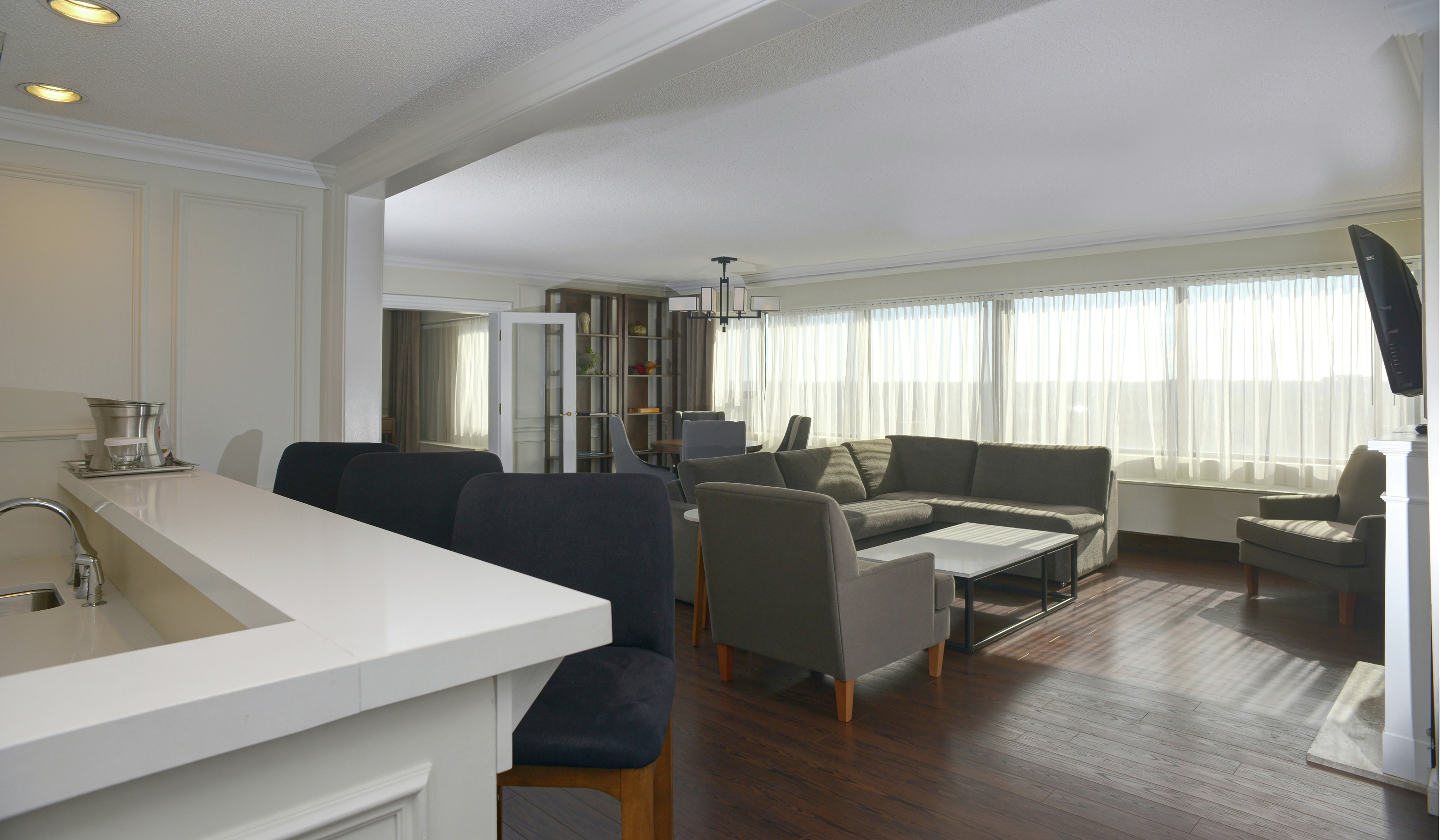 Prime Minister Suite Living Area with Sofa, Chairs, and Full Windows In Background