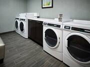 Guest Laundry Room With Wall Art, Coin Operated Washing and Drying Machines