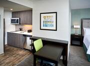 Kitchen, Work Desk With Green Task Chair, and View of King Bed in Studio Suite With Lake View  