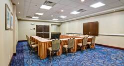 Meeting Space With Seating for 12 Around U-Table, Wall Mounted Audio/Visual Cabinet, and Wall Art