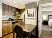 Suite Kitchen With Dining Table and View of Bedroom