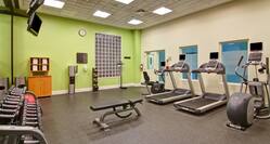 Fitness Center With Towel Station, Water Cooler, Weight Balls, Scale, Bench, Cardio Equipment, TVs Above Free Weights, and Red Stability Ball