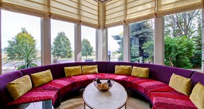 Purple Circular Seating and Table in Gazebo With Raised Shades
