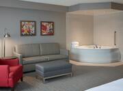 Guest Suite Lounge Area with Sofa, Armchair, Footrest and Whirlpool Tub