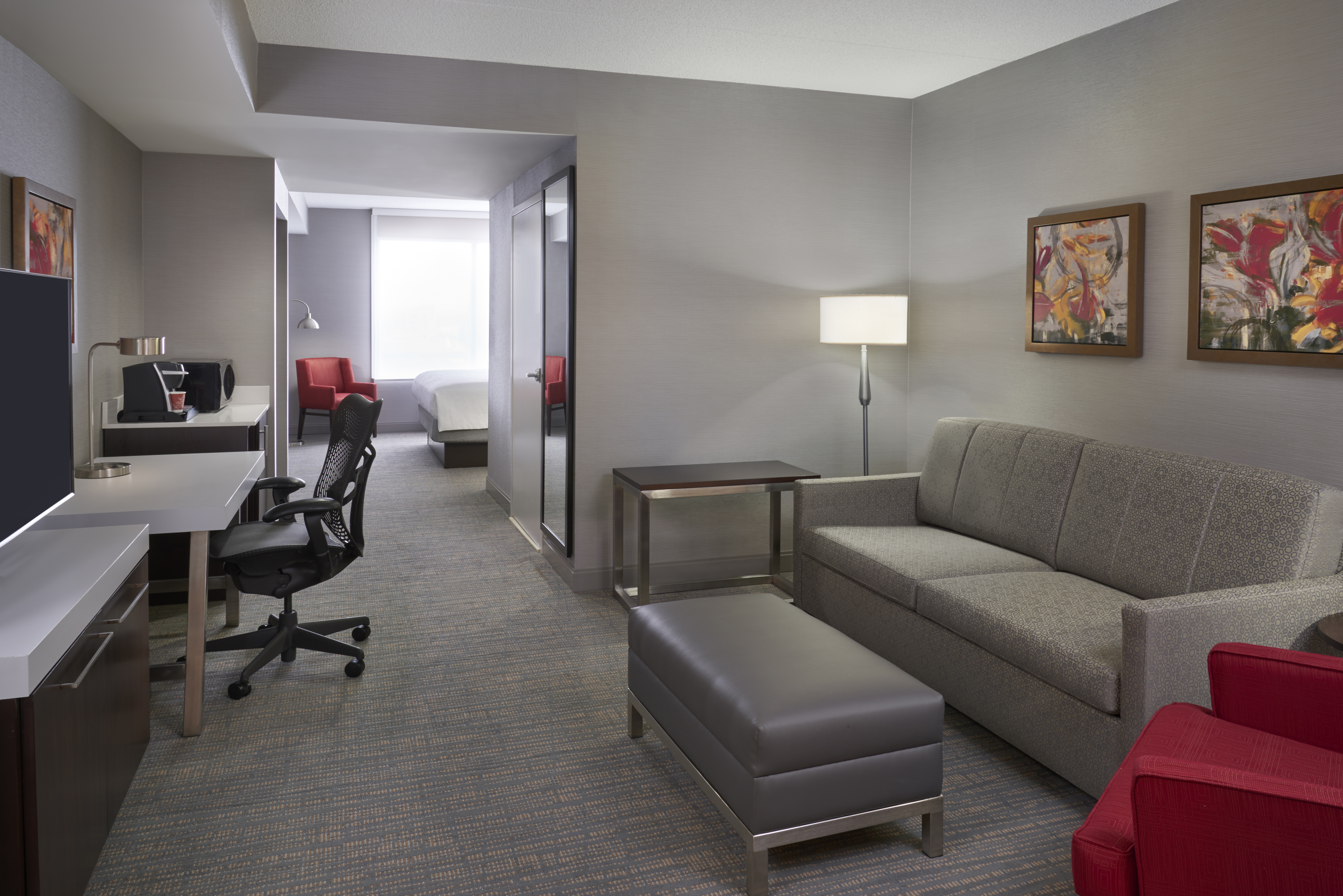 Guest Suite Lounge Area with Sofa, Footrest, Armchair, Work Desk and HDTV