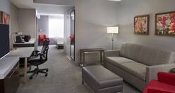 Guest Suite Lounge Area with Sofa, Footrest, Armchair, Work Desk and HDTV