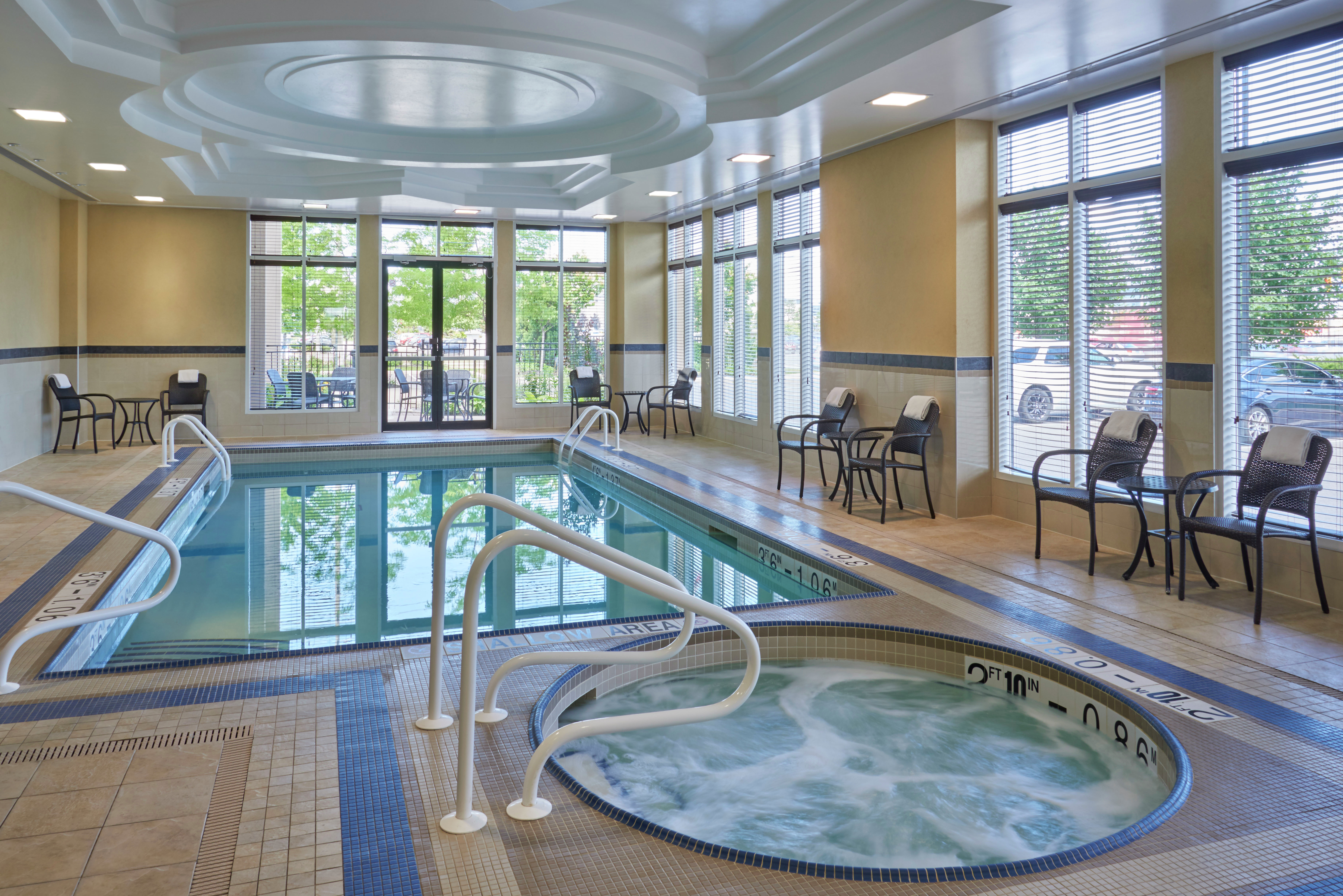 Tables, Chairs, and Windows by Heated Indoor Pool and Whirlpool.