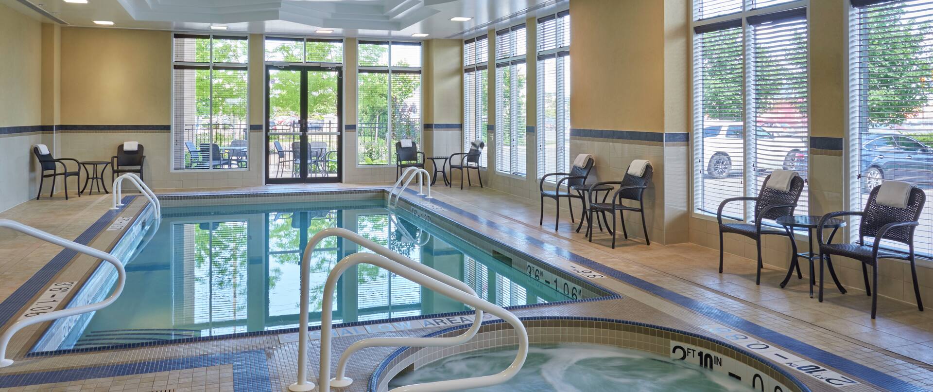 Tables, Chairs, and Windows by Heated Indoor Pool and Whirlpool.