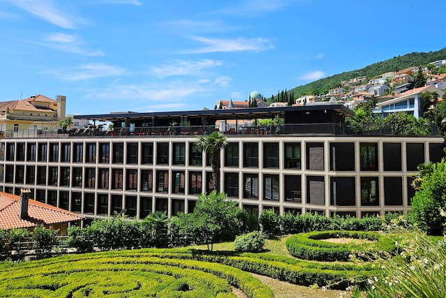 Extérieur de l'hôtel avec bâtiments et buissons environnants